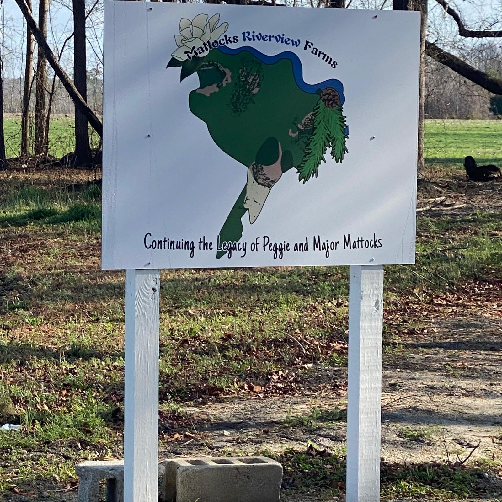 The Mattocks Riverview Farms foundation sign mounted on white posts at the farm entrance