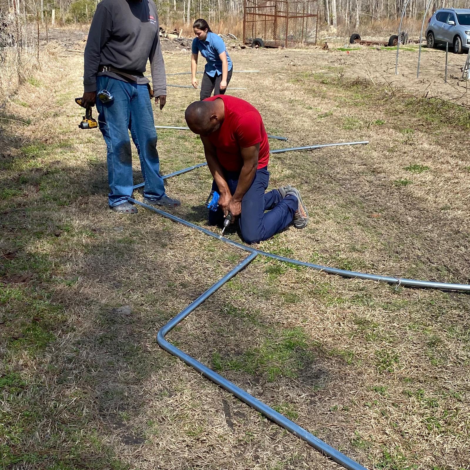 Volunteers assembling the high tunnel frame base