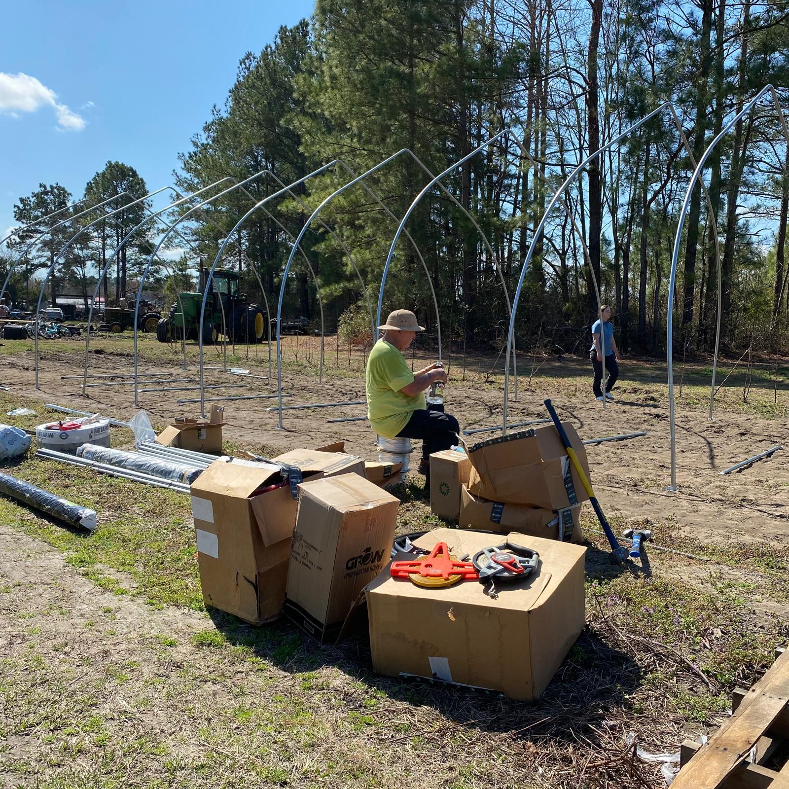 Community members working together to build the high tunnel
