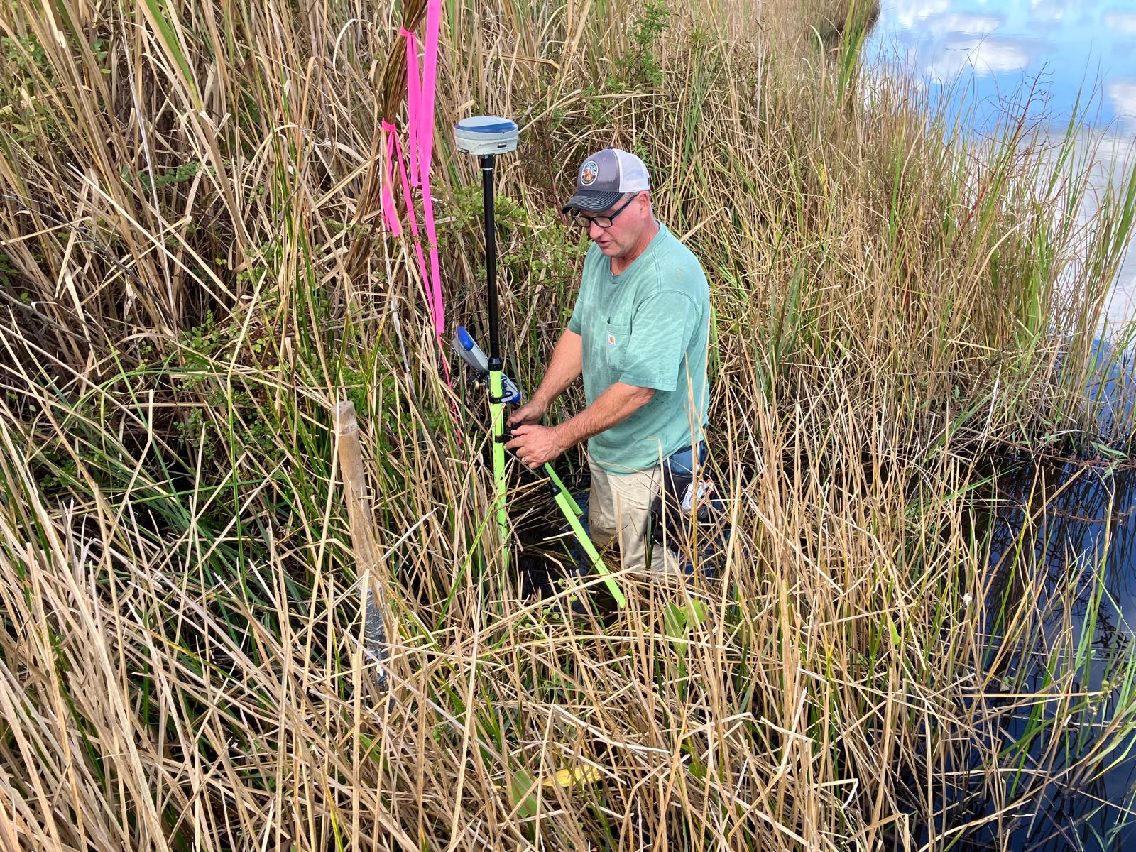 Surveyor installing a boundary marker on the bank of the White Oak River